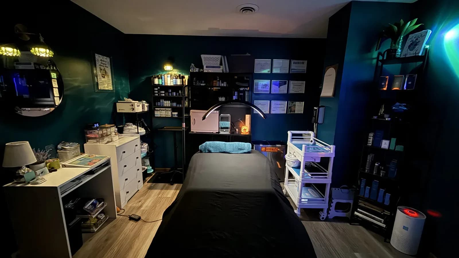 The treatment room at Esthetics By Kyrsta in North Canton, Ohio, with the facial bed, product shelves and equipment trolley