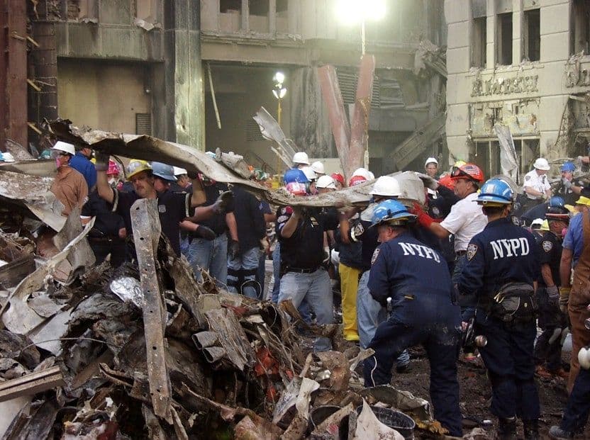 World Trade Center responders in hard hats work amid twisted debris at Ground Zero after the September 11 attacks